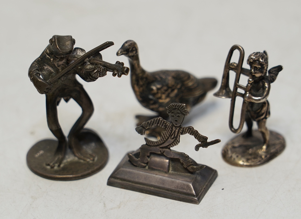 Two early 20th century miniature silver models of a goose and a cherub with trombone, 37mm, an 800 standard figural menu holder and a later silver model of a frog with violin. Condition - fair